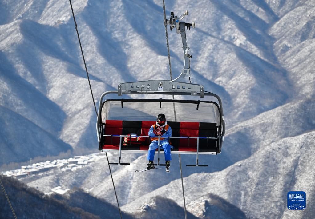 2月14日,怀伟乘坐缆车前往国家高山滑雪中心"冰川"雪道起点处备勤.